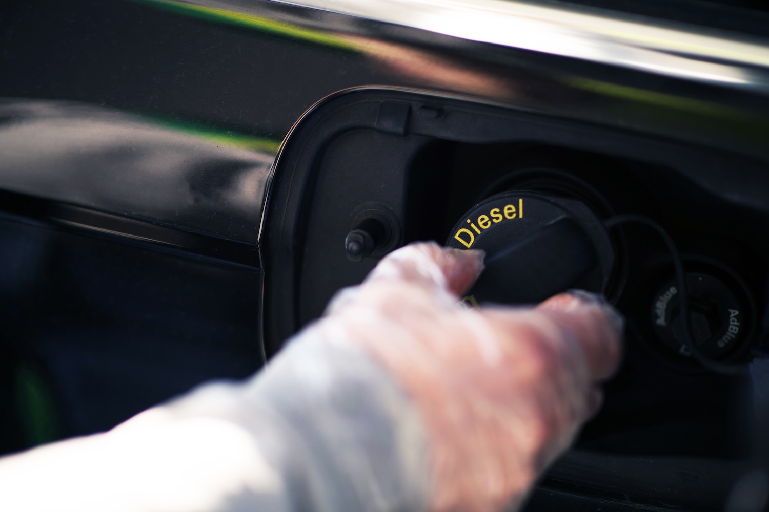 A man's hand putting diesel into his car, expressing the need for used dpf filters manchester