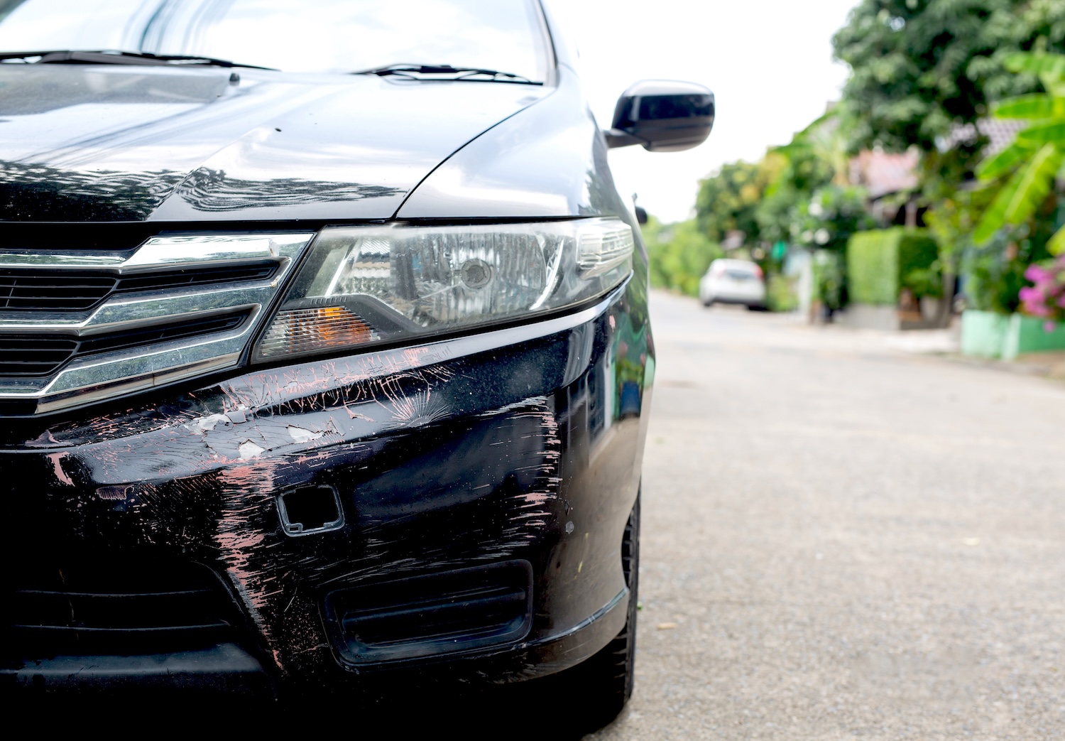 A black car bumper with scratches in the paint work