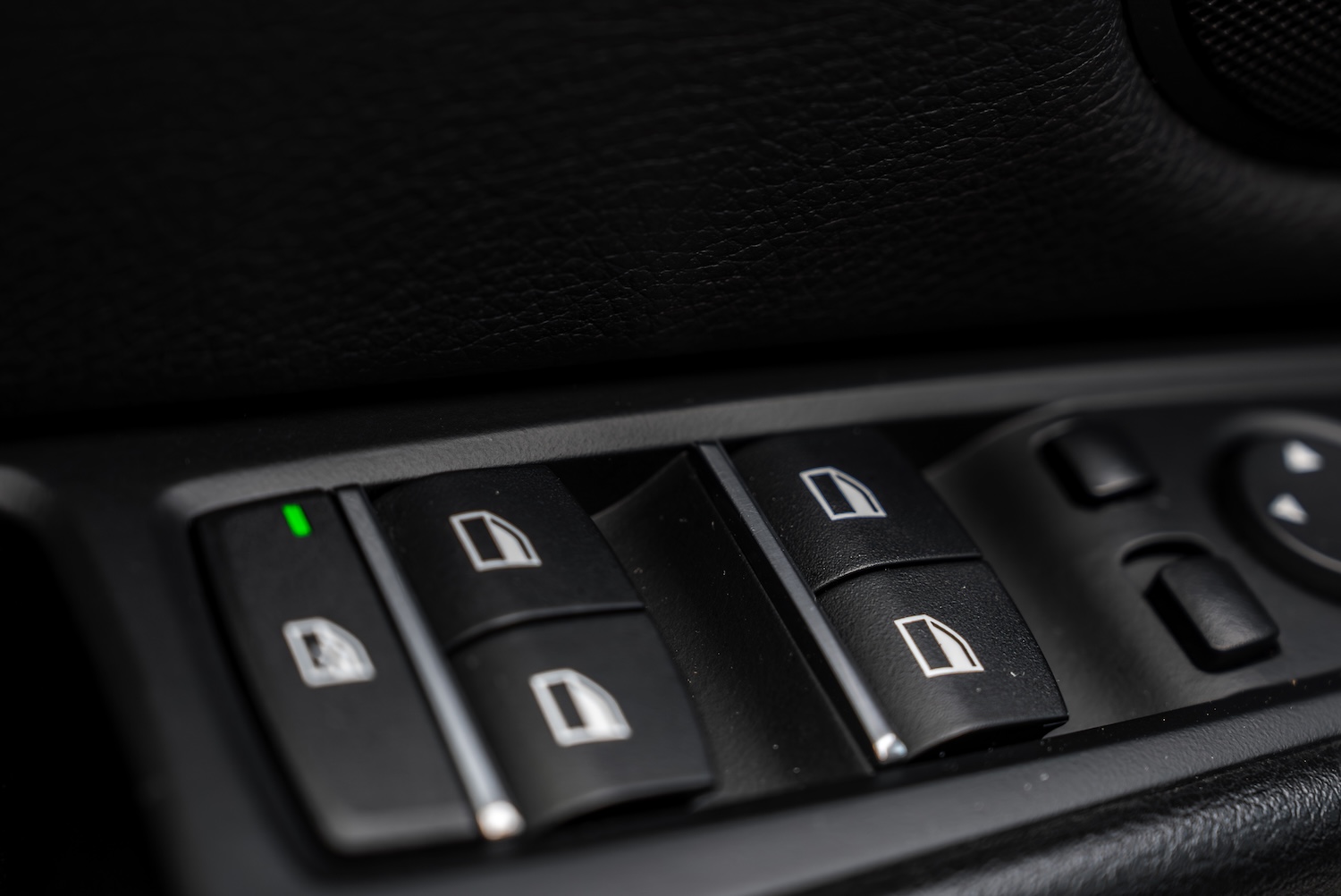 A car door control panel that uses a door control module (DCM) for windows